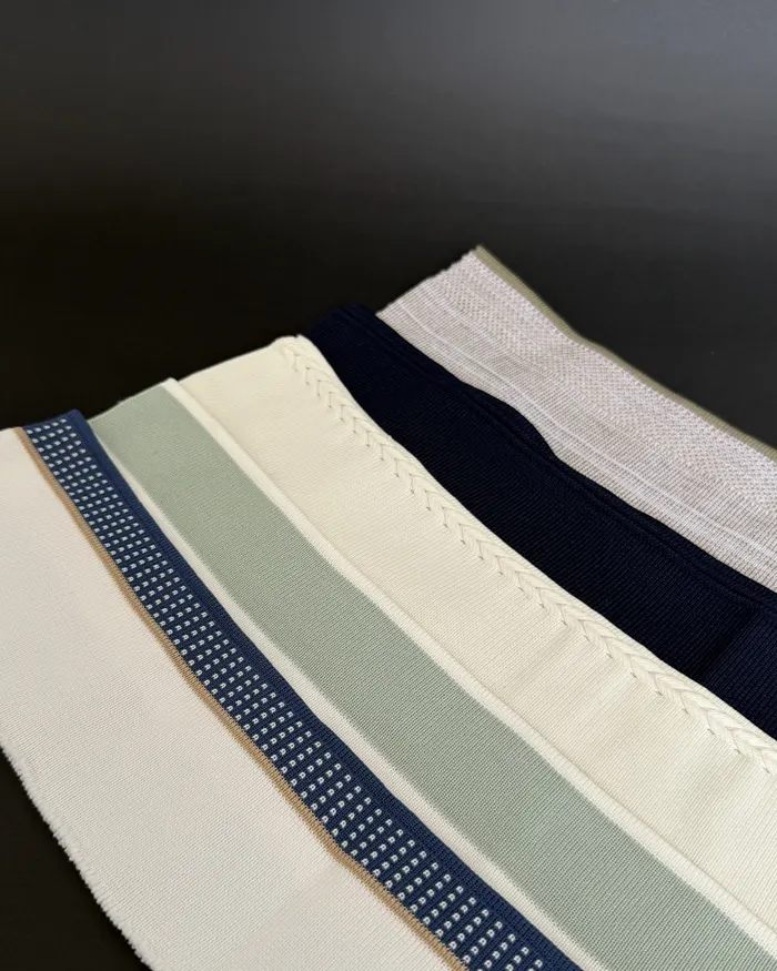 Pieza tejida con franjas diagonales en marfil, azul, gris y verde suave