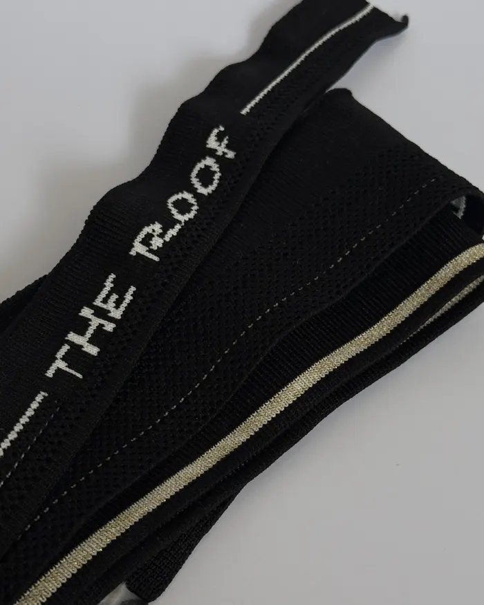 Detalle de tejido negro con la marca The Roof integrada en la pieza